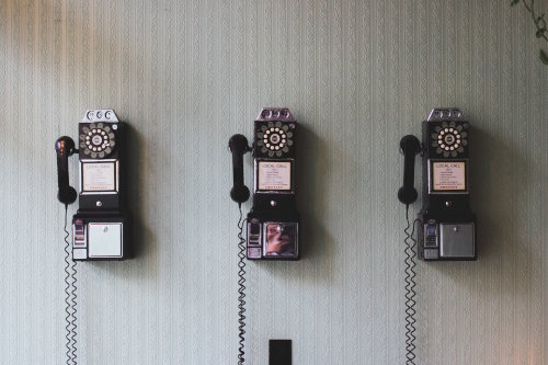 Three vintage telephones on a wall