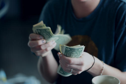 Woman counting out $1 bills